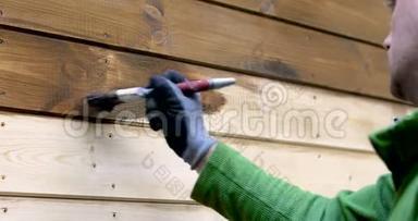 工人粉刷房屋外部，木质保护色